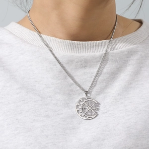 Λεπτομέρεια κολιέ με πυξίδα Vegvisir Viking φορεμένο πάνω σε λευκό πλεκτό πουλόβερ