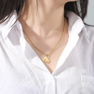 Detailed close-up of a golden elephant pendant necklace on a model wearing white shirt