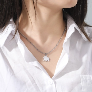 Close-up of minimalist silver elephant pendant necklace on model with white shirt