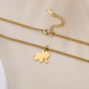 Detail of gold elephant pendant with Cuban chain and lobster clasp on satin background