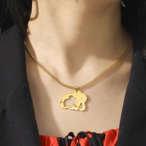 Detailed close-up of a gold hollowed elephant pendant necklace on a person