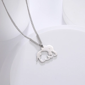 Detail of silver stainless steel elephant mother and calf cutout pendant on a pedestal