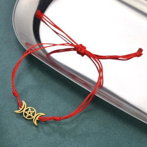 Detail eines roten geflochtenen Armbands mit goldenem Dreifachmond- und Pentagramm-Anhänger