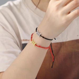 Nahaufnahme geflochtener Armbänder mit silbernen und goldenen Dreifachmond-Anhängern