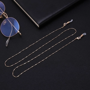 Détail d'une chaîne à billes en or rose pour lunettes avec bagues antidérapantes en silicone