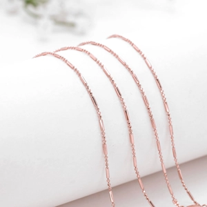 Chaîne de lunettes élégante en cuivre or rose avec perles et cylindres sur fond blanc