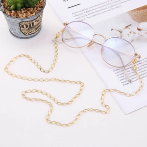 Close-up of golden hollow diamond glasses chain with lobster clasp on a white table