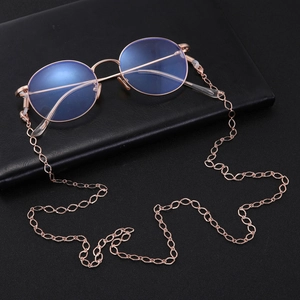 Detailed view of rose gold diamond-cut hollow metal eyeglass chain on black leather surface
