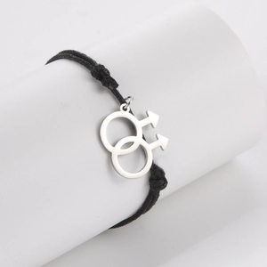 Detail view of woven black cord bracelet featuring silver double male symbol pendant