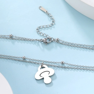 Détail du collier double couche en acier inoxydable avec perles et pendentif champignon