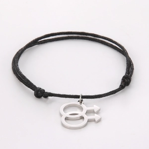 Macro shot of silver-tone double male symbol charm on a black braided cord bracelet