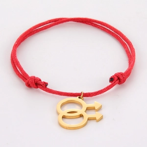 Detail of red braided cord bracelet featuring a gold double male symbol charm