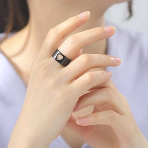 Close-up van zwart matte roestvrijstalen ring met hol hartontwerp gedragen door model