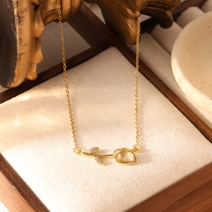 Detail van tulp hanger met gele edelsteen en zirkonia op een gouden dames ketting