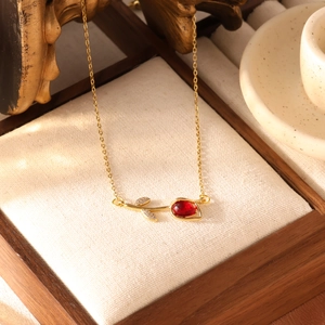 Detail van de gouden tulpenketting met rode steen en kristallen bladeren