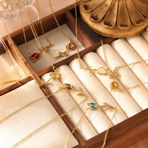 Close-up van gouden tulpkettingen met kleurrijke edelstenen in een luxe houten sieradendoos
