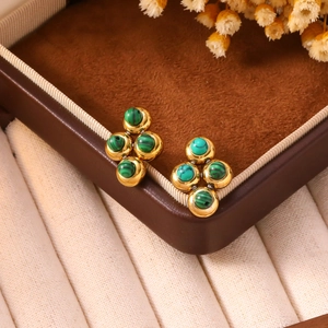 Dettaglio di orecchini in acciaio al titanio dorato con quattro perle verdi stile malachite