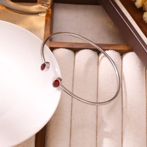 Dettaglio del bracciale aperto in acciaio inossidabile con due pietre di zircone rosso