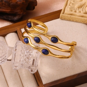 Detailaufnahme des wellenförmigen 18K vergoldeten Armreifs mit blauen Lapislazuli