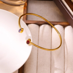 Bracciale dorato minimalista con pietre preziose circolari in rosso e viola