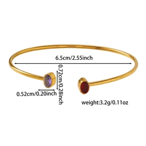 Dettaglio del bracciale aperto dorato con pietre preziose ovali viola e rosse e misure