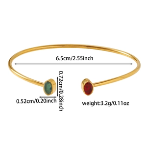Dettaglio del bracciale aperto dorato con gemme ovali verdi e rosse e diametro 6,5 cm