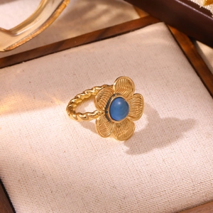 Macro shot of 18K gold flower ring featuring turquoise center and twisted band detail