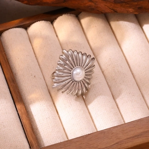Vue détaillée d'une bague argentée vintage avec perle blanche et motif de texture solaire
