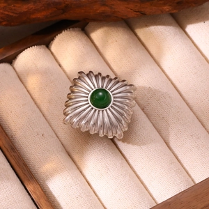 Gros plan d'une bague vintage en argent avec agate verte ronde dans un écrin de luxe