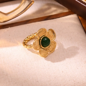 Vintage 18K gold plated flower ring with green stone and twisted band on a tray
