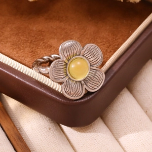 Macro shot of silver flower ring with twisted band and yellow turquoise center
