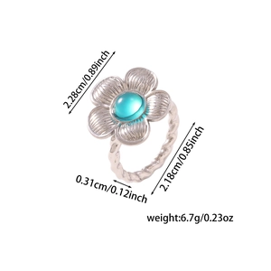 Macro view of flower-shaped ring with turquoise center and rope-textured silver band