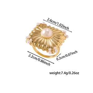 Vue détaillée d'une bague dorée vintage avec perle centrale et plaque carrée à texture rayonnante