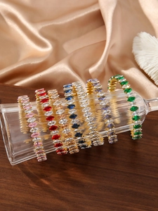 Dettaglio di bracciali con zirconi colorati taglio marquise su un vetro di lusso