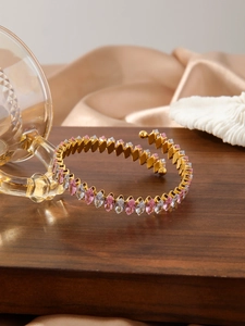 Dettaglio del bracciale a spirale in oro 18K con zirconi marquise rosa e trasparenti