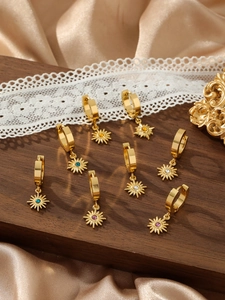 Detailed close-up of vintage sunburst huggie earrings with colorful zircon stones