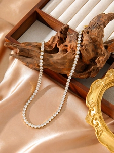 Détail du collier tennis plaqué or 18 carats serti de zircons sur un tissu de soie