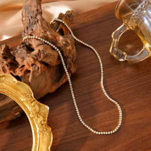 Collier tennis classique plaqué or 18 carats avec zircons brillants sur présentoir bois