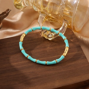 Bamboo style stainless steel bangle with light blue enamel and golden metal accents