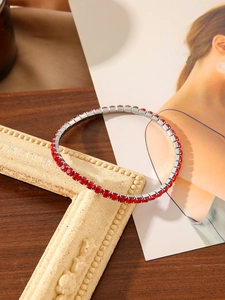Detail of red zircon tennis bracelet on silver base with sparkling round cut stones