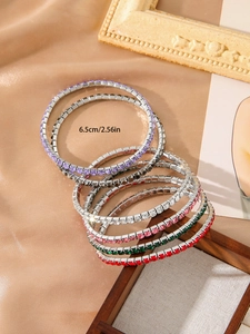 Detail view of multicolored crystal tennis bracelets with 6.5cm diameter on silk background