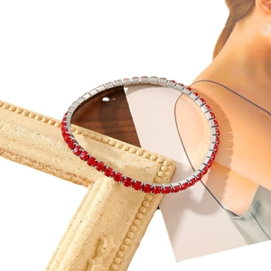 Elegant silver tennis bracelet with sparkling red zircons on minimalist background