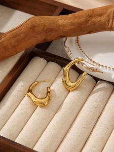 Detailed close-up of 18K gold-plated irregular lava texture earrings in a jewelry box
