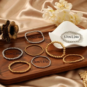 Polished gold and silver titanium steel beaded stretch bracelets in various bead sizes