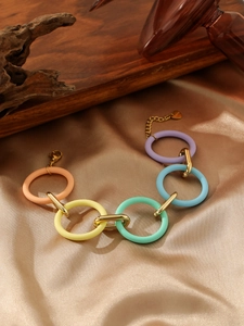 Detail of candy-colored acrylic links and gold stainless steel chain on satin