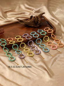 Detail of colorful acrylic rings and stainless steel chain with heart charm pendant