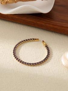 Detail of 18k gold plated tennis bracelet with purple oval-cut cubic zirconia stones