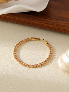 Detail of 18k gold plated tennis bracelet featuring vibrant orange oval-cut crystals