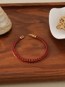 Detail of 18k gold plated tennis bracelet with sparkling red oval crystals and secure clasp