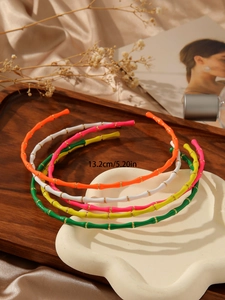 Detail showing five colorful bamboo style headbands with gold metallic rings and 13.2cm size